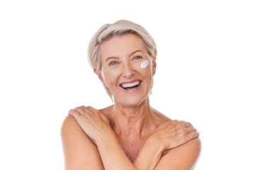 Portrait of one happy mature caucasian woman posing topless against a purple copyspace background. Ageing woman applying cream, moisturiser, sunblock during a skincare routine in a studio