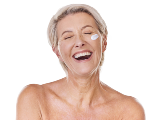 One smiling happy mature caucasian woman posing topless against a purple copyspace background. Ageing woman applying cream, moisturiser, sunblock during a skincare routine in a studio