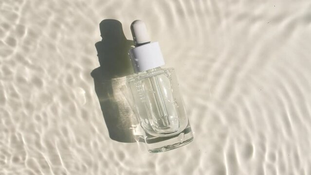 Glass bottle with pipette. Cosmetic vial for oil, liquid essential, collagen serum on water with drops. Women's cosmetics skincare. Sample of layout of package beauty product. High quality 4k footage