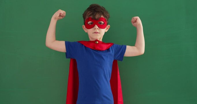 Funny little power super hero child (boy) in a red raincoat. 