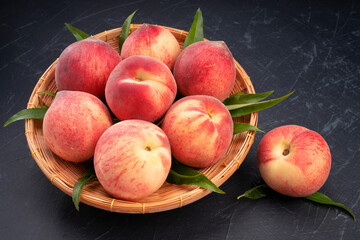 Peach fruits with leaf on black background, Fresh Peach fruits on wooden plate over black background.