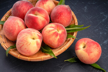 Peach fruits with leaf on black background, Fresh Peach fruits on wooden plate over black background.