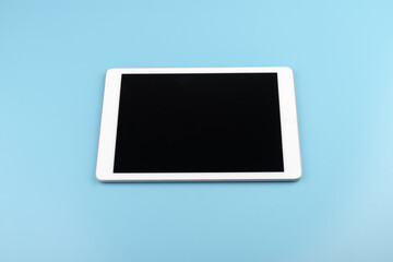 Top view of tablet on the blue pastel color background.