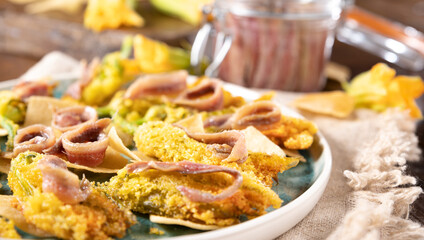 Pumpkin flowers fried with anchovies and cheese. Traditional cuisine of Italy, south of Italy and Sardinia. Little salty fish and flowers. Close-up