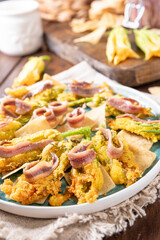 Pumpkin flowers fried with anchovies and cheese. Traditional cuisine of Italy, south of Italy and Sardinia. Little salty fish and flowers. Close-up