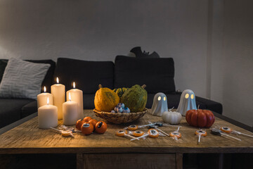 mesa llena de velas y decoraciones con dulces y tazas para halloween