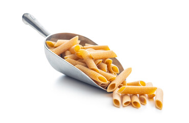 Uncooked whole grain pasta isolated on white background. Raw penne pasta in scoop.