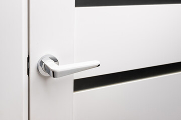 Door handle on white closed doors in modern loft style in interior.