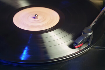 Detail of a retro record player with a spinning black vinyl record