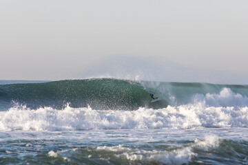 surfer getting barrelled on a wave