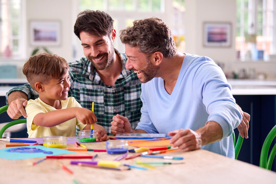 Same Sex Family With Two Dads And Son Painting Picture In Kitchen At Home Together