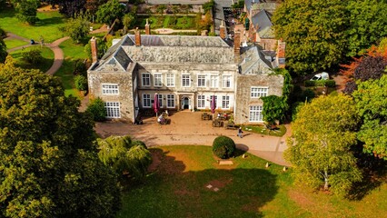 Aerial view of the Cockington Court surrounded by parks, Devon, England