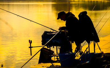 A fisherman is fishing on a spinning rod on the city embankment. 