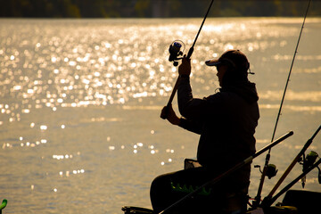 A fisherman is fishing on a spinning rod on the city embankment. 