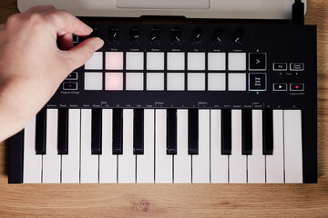 Midi Keyboard musician hand playing midi keyboard for arranging music on laptop computer Music...