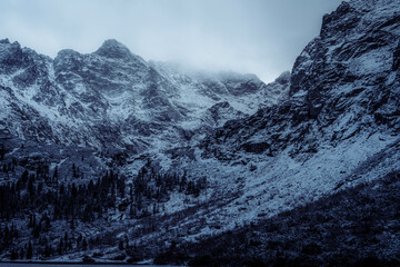 Snowy mountain peaks at Morskie Oko, Poland on a foggy, cold winter afternoon.
