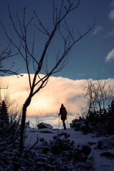 Hiking woman silhouette over the horizont at sunset