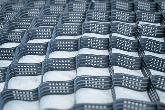 Polymeric geogrid for strengthening slopes. Industrial grid of cells for earthworks.