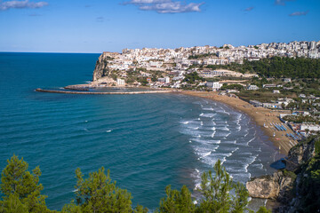 white houses on a hill by the Adriatic Sea in Italy. Historical village buildings in Italy view from the sea on a clear day. Italian coast with a small town on a hill