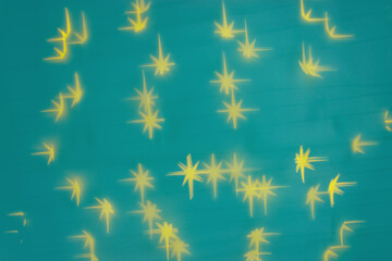 Bokeh as lights yellow stars on Emerald green background, abstract winter holiday wallpaper with optical blurred pattern. Christmas or New Year abstract image as backdrop, blur background