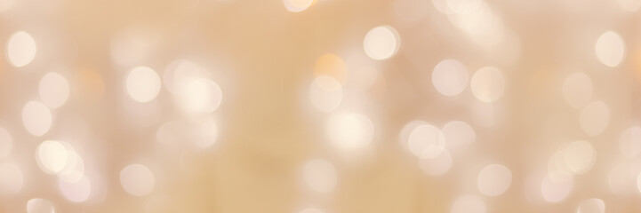 Defocused abstract bokeh background beige pastel colored, flare from lights, beige monochrome photo, blurred round bokeh as holiday fon, celebration wide banner. Glittering aesthetic pattern