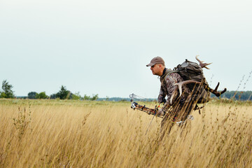 Hunter in the woods with bow and arrow ready to take aim at his prey