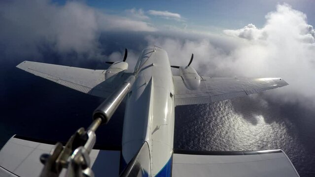 External perspective of twin engine plane flying over ocean