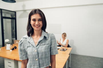Obraz premium Portrait of businesswoman working and looking camera with business team behind in a meeting room. 