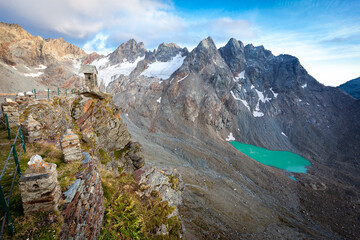 Old stone bell tower high Alps mountains cliff glacier, Refuge Marinelli Bombardieri , Bernina range mountaineering tourism, Italy travel Europe.