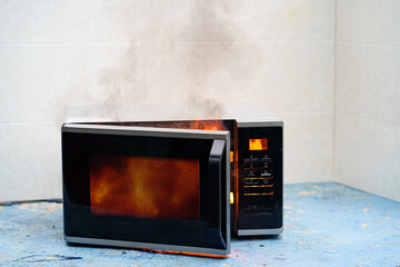 microwave oven on fire. the concept of fire in the kitchen and malfunctions, breakdowns of electrical appliances and wiring, installation of fire safety systems. - obrazy, fototapety, plakaty