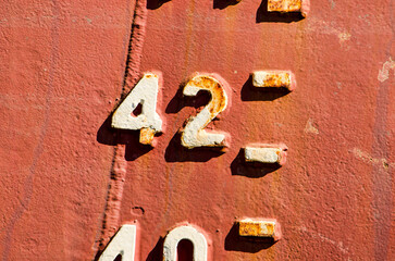 Close-up of the draught marks on a weathered ship's hull, focussing on the number 42