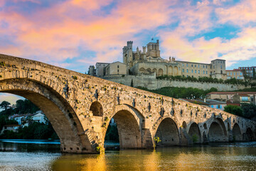 Obraz premium The old bridge and the Saint-Nazaire cathedral and their perfect reflection in Béziers in the Hérault in Occitanie, France.