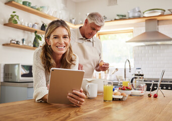Tablet, baking and retirement with a senior couple cooking in the kitchen of their home together....