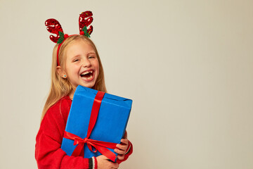 Smiling funny child (kid, girl)  holding Christmas gift box