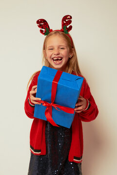 Smiling funny child (kid, girl)  holding Christmas gift box