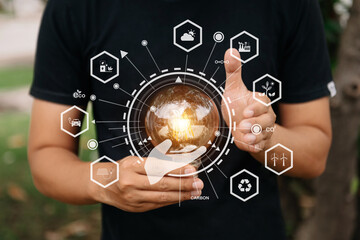 Hand holding anti nature light bulb on green leaf with renewable and sustainable development energy source icon. for renewable,love the world