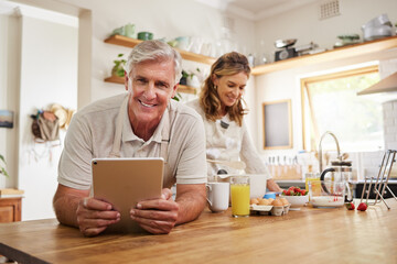 Portrait, senior couple and cooking with tablet together in a modern kitchen of the home. Happy,...