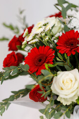 Large bouquet of red and white flowers with green twigs