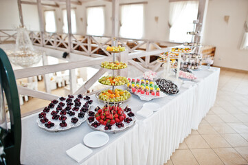 Beautiful wedding candy bar with sweets, fruits and food. Wedding banquet table