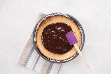 Gateau au chocolat. Recette en préparation. Dessert maison. Cuisine tendance. Pâte brisée. Pâte feuilletée. Ingrédients sur la table. Minimaliste, vue du dessus, fond blanc texture.