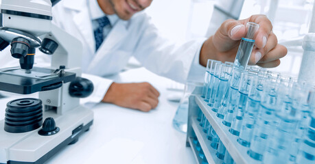 Chemist looking at test-tubes with blue liquids