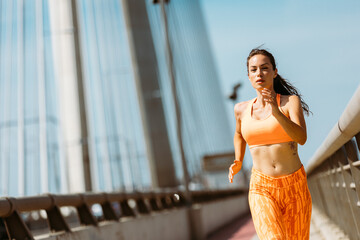 Fit fitness woman running outside over bridge. Healthy lifestyle concept