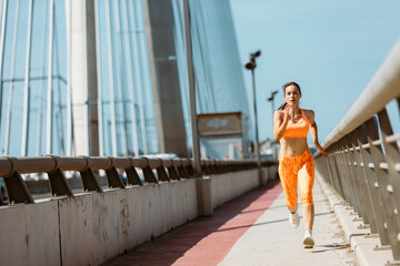 Fit fitness woman running outside over bridge. Healthy lifestyle concept
