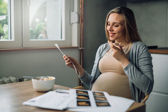 caucasian pregnant woman talks to her doctor on mobile phone