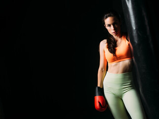 Beautiful fit woman posing with red boxing gloves.
