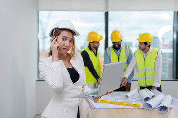 Portrait of Female inspectors holding laptop and architects discuss with head engineer about construction project, team discussion with construction on site work.