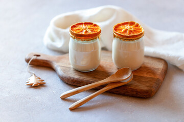 Two portions of joghurt decorated with dry orange slices, winter breakfast