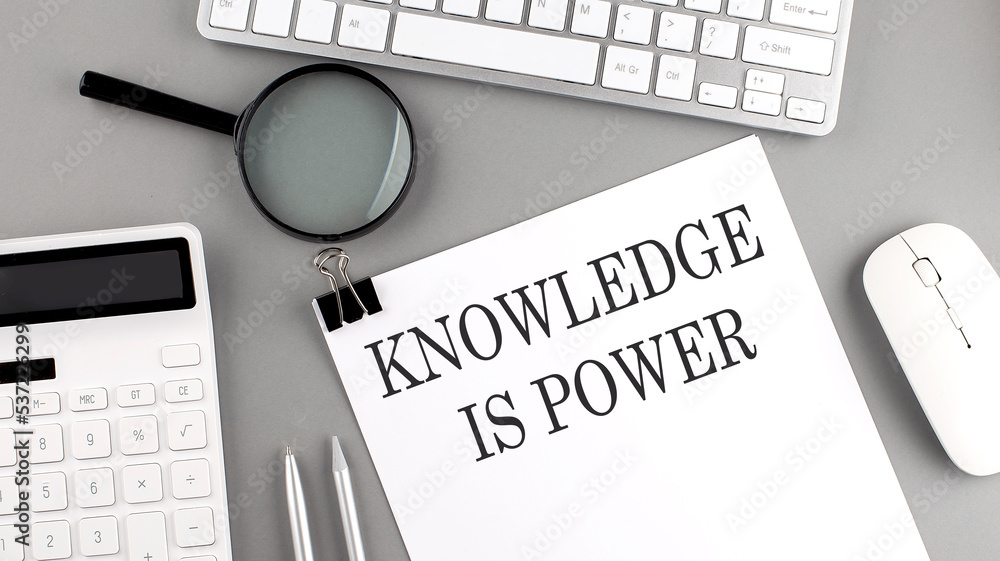 Poster knowledge is power written on paper with office tools and keyboard on the grey background