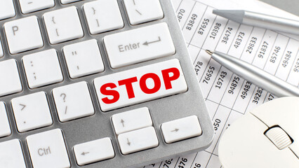 STOP text on a keyboard wirh chart and pencil