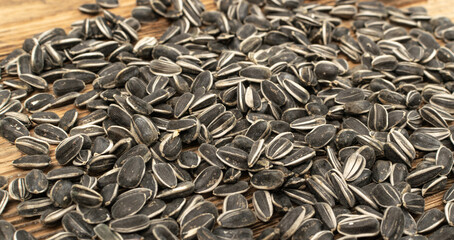 Sunflower Seeds, Striped Raw Seeds on Wood Background Texture Closeup